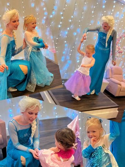 Two women dressed as Elsa from Frozen entertaining young girls in princess dresses.