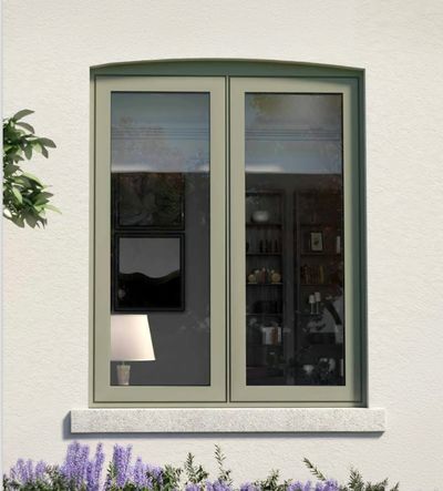 Modern window with beige frame and indoor lamp visible, surrounded by purple flowers.
