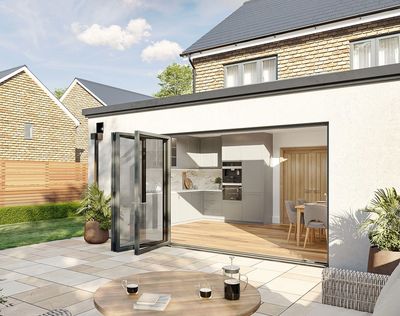 Modern kitchen with glass doors opening to a sunny patio with coffee setup.