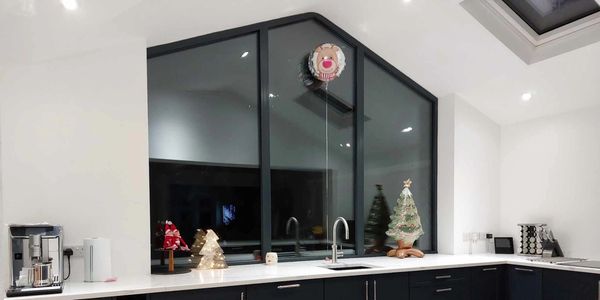 Modern kitchen with black cabinets and festive Christmas decorations on the counter.