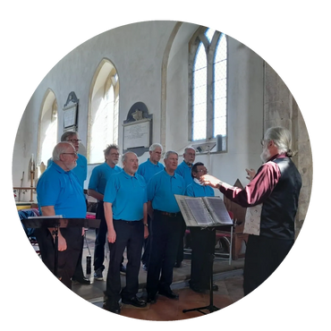 A men's choir rehearsing under a conductor in a church.