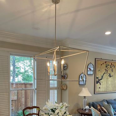 Sleek chandelier installation in the living room