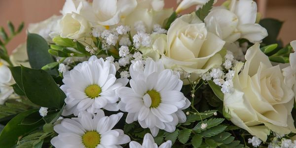 Funeral flowers in whites, creams and greens pictured