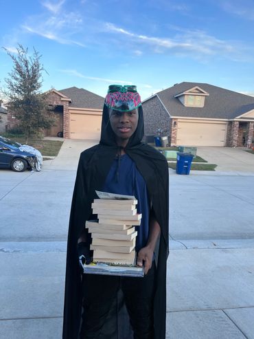A teenager smiling proudly after discovering a stack of chapter books at the event — he was so excit