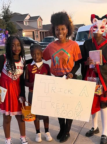 Mrs. Kaysee Williams smiling with children as they proudly hold their books — a joyful moment celebr