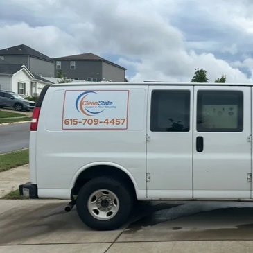 White Clean State service van parked on a residential street under cloudy sky.