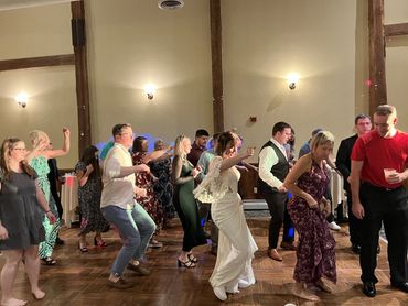 A group of people dancing together at a lively indoor event.