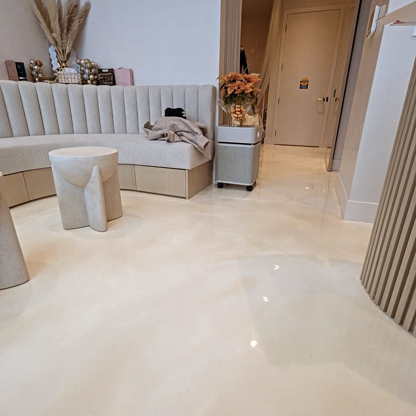 Modern minimalist beige sitting area with unique stool.