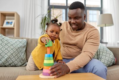 Image of a father playing with a stacking toy with his child