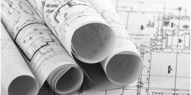Rolled architectural blueprints on a flat blueprint.