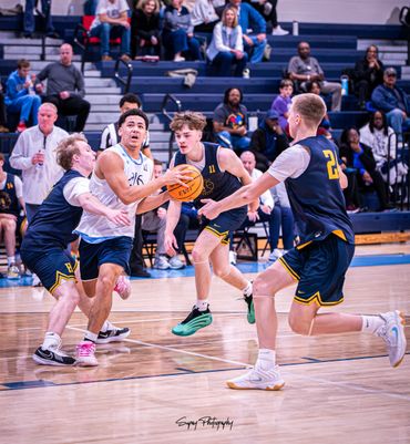 Intense basketball game with players battling for the ball on the court.