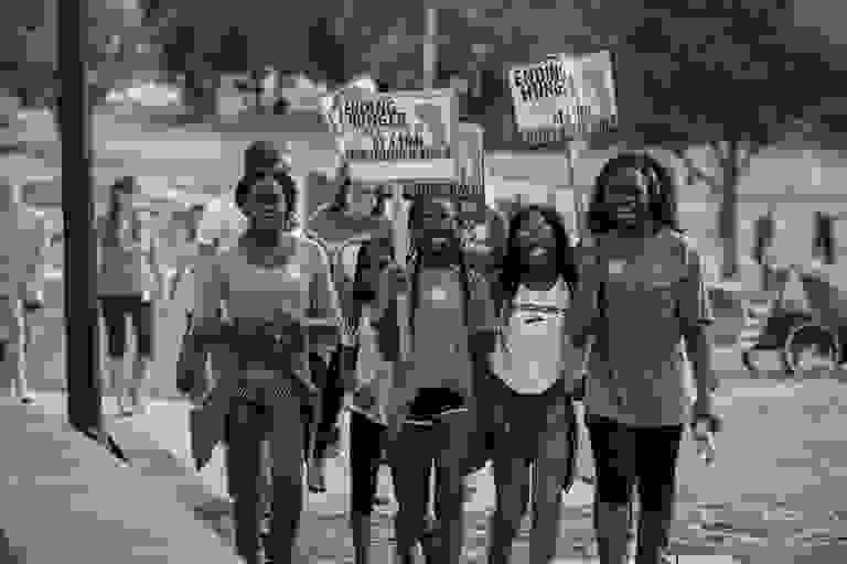 Students walking carrying signs