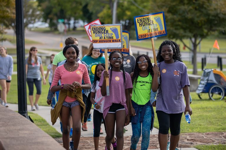 Students walking carrying signs