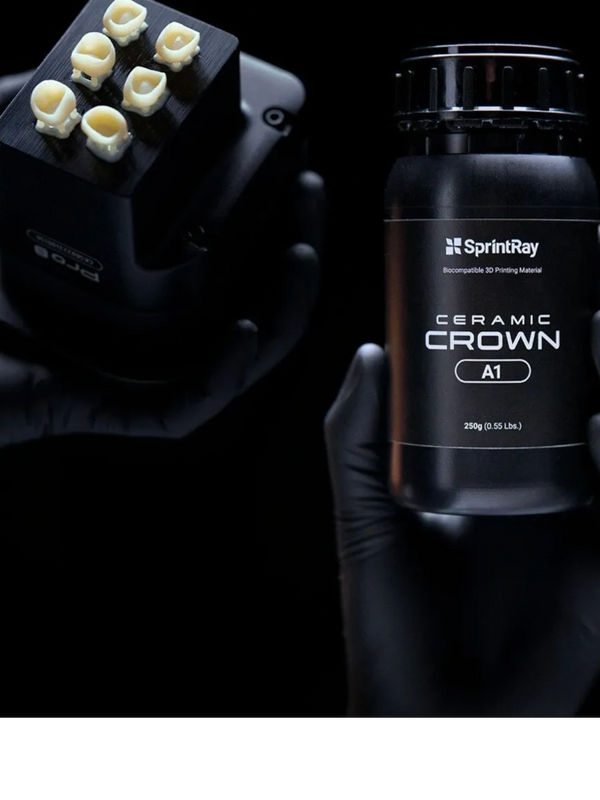 Hands hold a SprintRay Ceramic Crown 3D printing material and a block with dental crown prints.