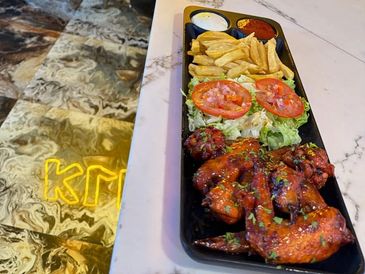 Plate of chicken wings, fries, and salad.