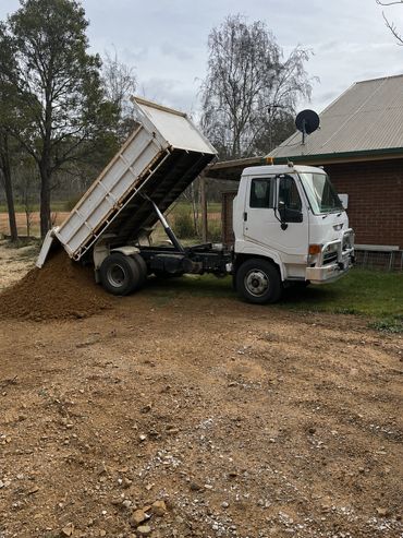 unloading material for a hard stand near a house in Adaminaby.
