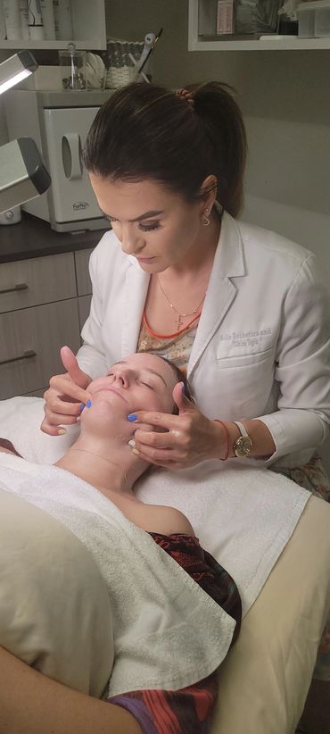 Esthetician performing a relaxing facial massage on a client at a spa.