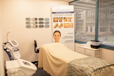 A serene spa room with a treatment bed and skin rejuvenation equipment.