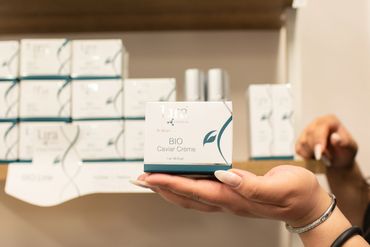 Hand holding a Lira Clinical BIO Caviar Crème skincare product.