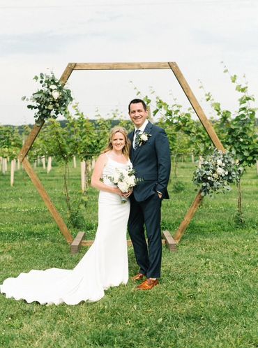 micro wedding with couple standing in front of a octagon shaped wedding each in a vineyard