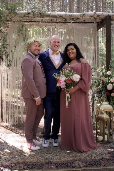 Queer wedding flowers under a arch in the woods in Wisconsin