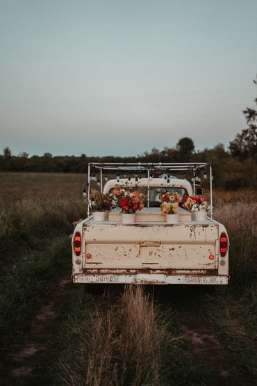 Wisconsin flower truck in a open field with buckets full of flowers in the back end