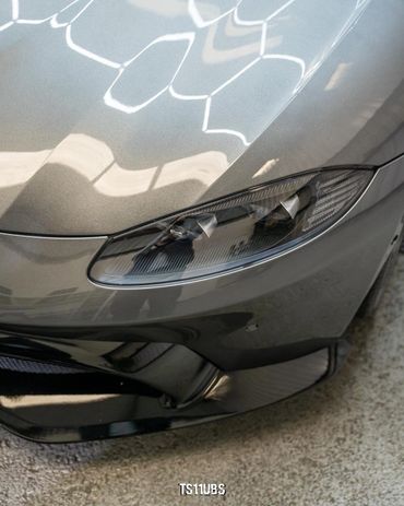Close-up of a sleek car headlight with reflective surface.