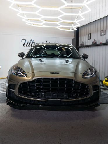 Front view of a sleek Aston Martin sports car in a showroom.