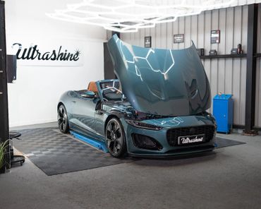 Sleek convertible sports car with open hood in a modern garage.