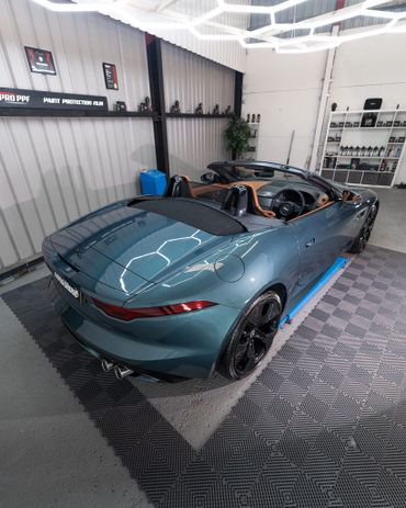 Sleek blue convertible sports car inside a modern garage.