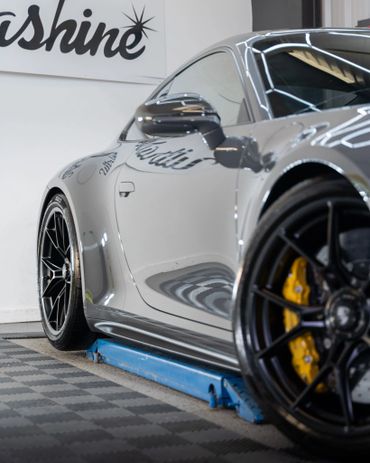 Sleek silver sports car with black rims and yellow brake calipers.
