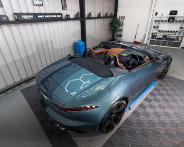 A sleek convertible sports car inside a detailing workshop.