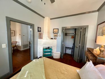 Cozy bedroom with white brick fireplace and rustic wooden furniture.