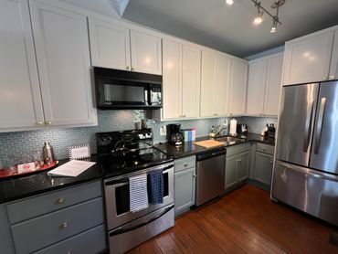 Modern kitchen with stainless steel appliances and white and gray cabinetry.