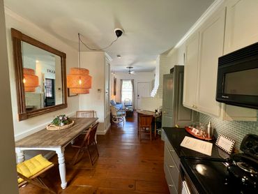 Cozy, narrow kitchen and dining area with wooden floors and warm lighting.