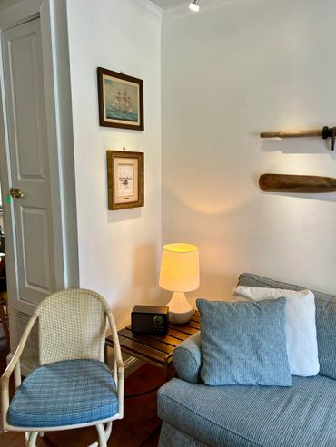 Cozy corner with striped cushions, wooden chair, and soft lamp light.
