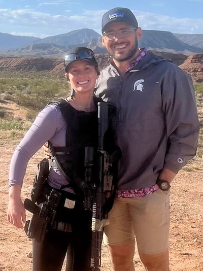 Mikenzie poses with her husband and her rifle