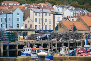 A harbor with fishing boats and colorful buildings in the background.