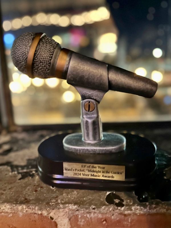 A microphone-shaped music award with a blurred background.