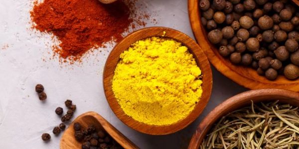 Various colorful spices in wooden bowls.