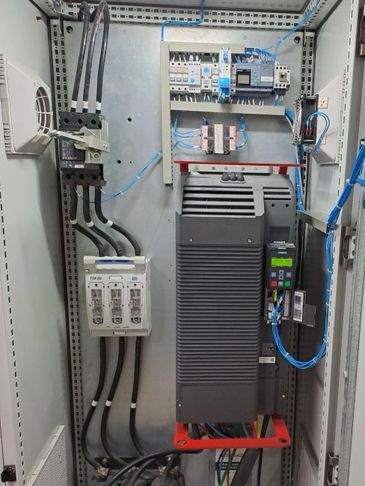 Inside view of an electrical control panel with wiring and circuit breakers.