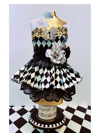 Harlequin fantasy dress on form.  Gold leaf, musical base.
