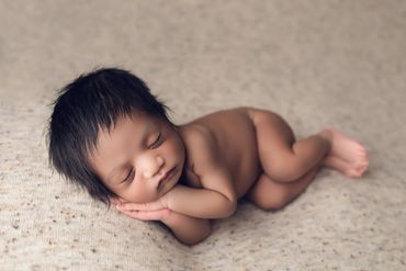 posed newborn baby with lots of hair and hands sleepy with st. louis newborn photographer