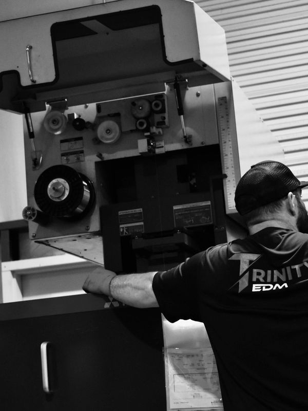 Photo of a Trinity EDM employee working in the EDM shop