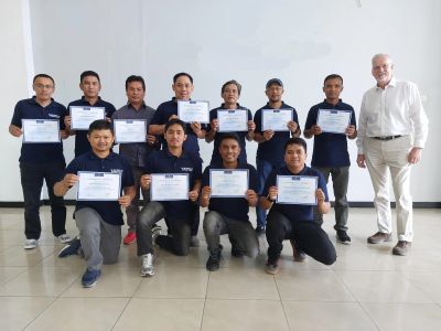 Groep mannen poseert met certificaten.