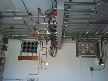 Wires and pipes organized along a building's ceiling.