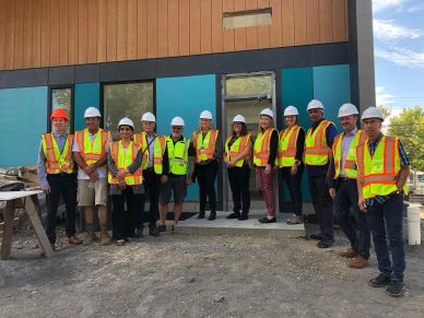 Group of construction workers in safety gear standing at a site.