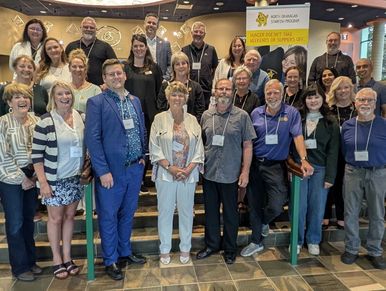 Group photo of diverse professionals at an indoor event.