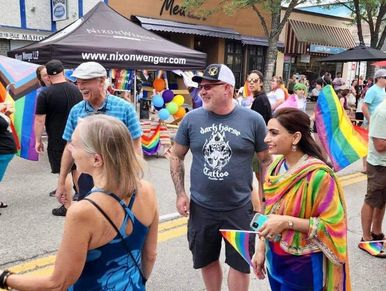 People celebrate at a pride event with rainbow flags.