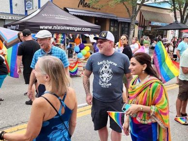People celebrate at a pride event with rainbow flags.